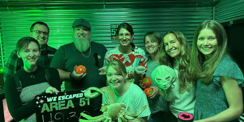 The Eternity Team having a group photo taken inside an escape room after completing it